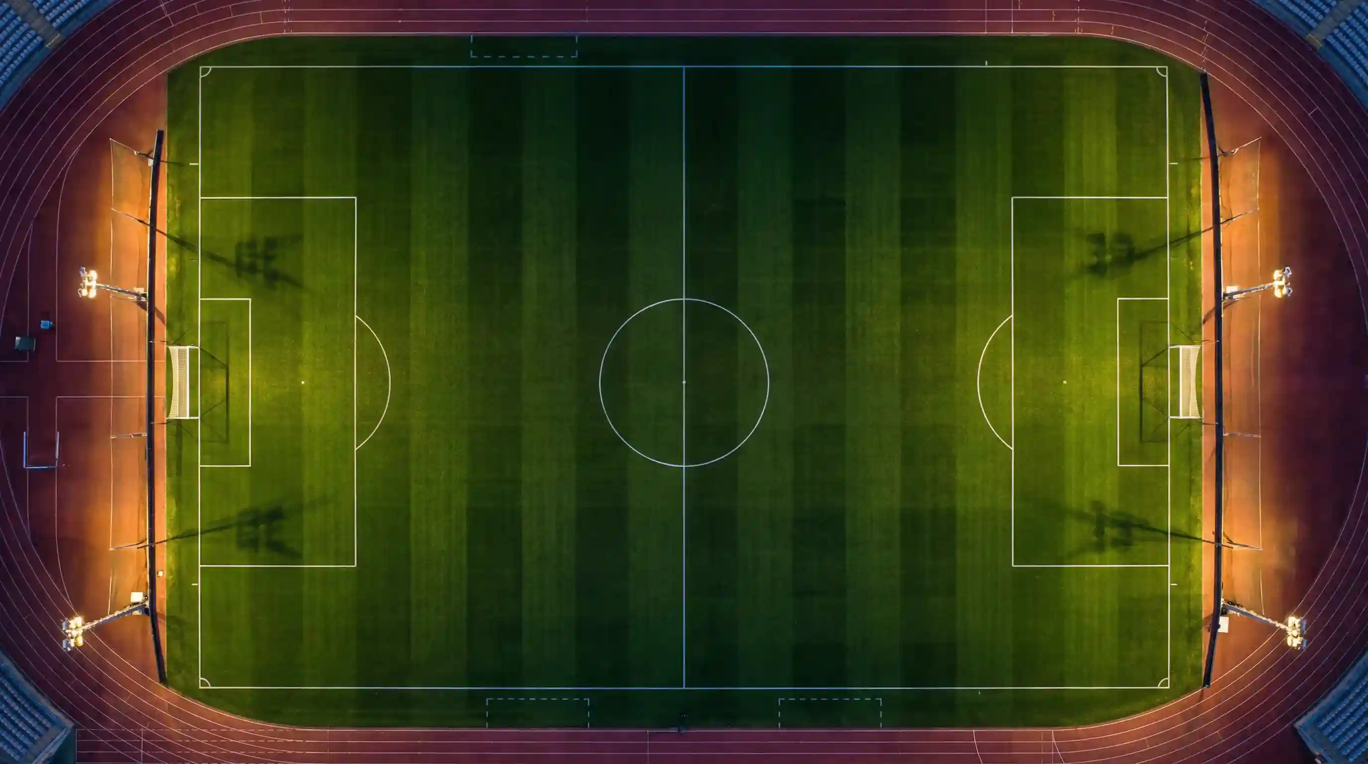 Campo di calcio visto dall'alto con linee di gioco illuminate